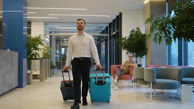 Friendly hotel employee helping an elderly female tourist with her luggage