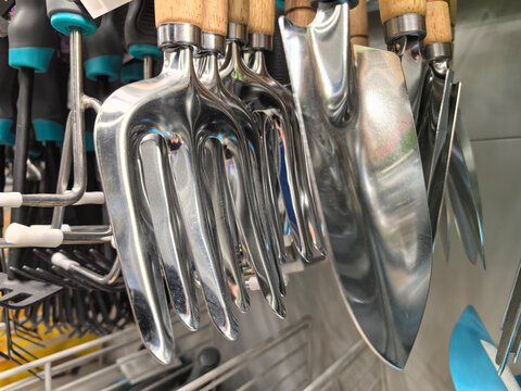 Shiny gardening tools hanging in a colorful display at the local store
