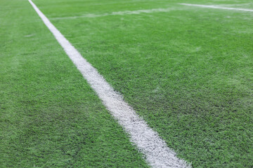 Obraz premium soccer field with green grass, white markings, and a corner flag.. The image captures part of the pitch used in professional matches, highlighting sports atmosphere and game preparation