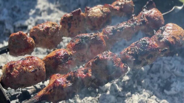 Grilling marinated meat skewers on charcoal grill outdoors