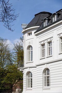 Stylish Neoclassical House With Bright Windows. Peaceful Mansion With Curved Roof And Surrounding Trees