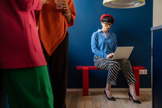 Creative businesswoman working on laptop in modern space