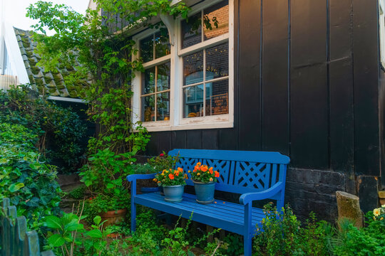Blue bench with flowers by a cozy Amsterdam house