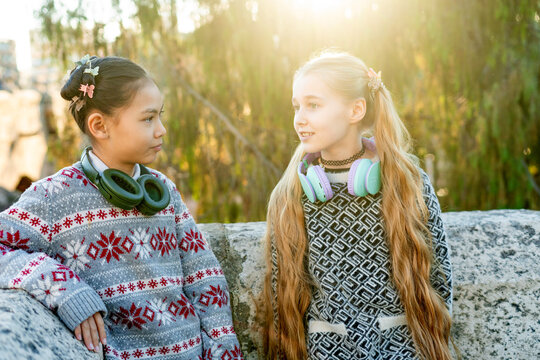 Two girls with headphones enjoying a sunny day outdoors