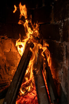 Burning firewood in brick fireplace with warm flames