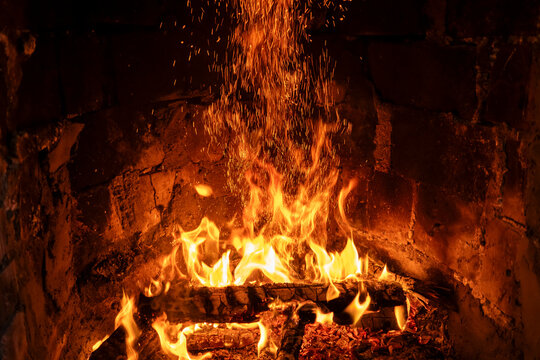 Warm fireplace fire with flames, sparks and glowing embers
