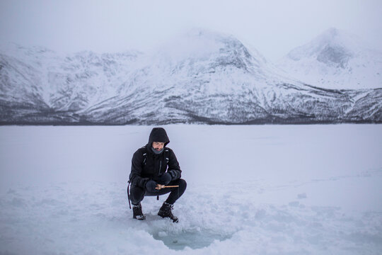 Winter ice fishing on a frozen lake near Tromso, Norway