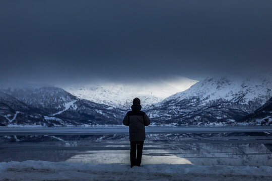 Lone traveler admiring Arctic fjord near Tromso, Norway