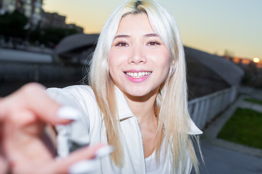 Gen Z woman smiling at dusk in urban street portrait