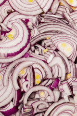 Obraz premium Close up of sliced red onion with layered texture background Fresh chopped red onion rings with detailed vegetable texture Raw purple onion slices as food background and cooking ingredient