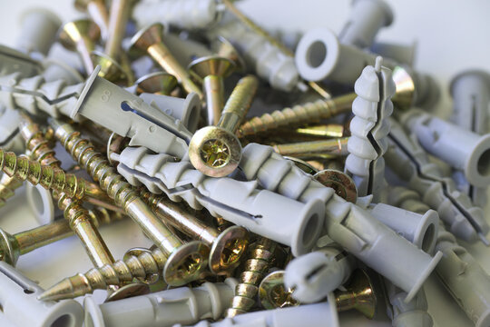 Pile of screws and plastic wall plugs for construction