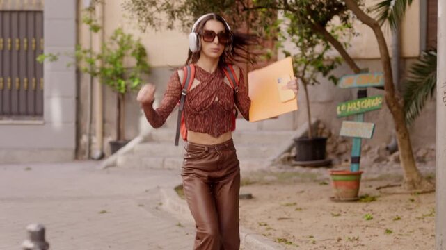 Happy young student dancing in the street