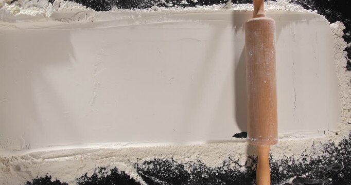 Rolling pin moving through flour across frame baking process