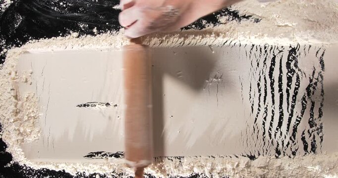Chef rolling pin over flour baking process close up kitchen