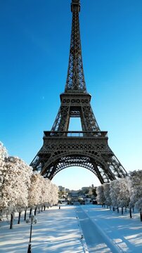 Snow-Covered Paris Street Perspective with Eiffel Tower Dominating the Sky