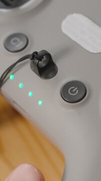 Vertical video. Finger Pressing Power Button on FPV Drone Controller with Connected Joystick and Active LED Indicators, Close-Up Macro View, Startup Concept