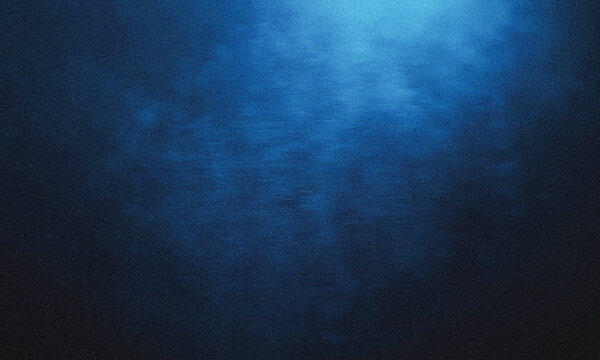 Blue underwater light rays shining through deep ocean water with soft gradient texture and dark atmosphere creating calm aquatic background