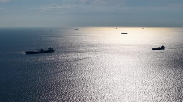 Aerial shot of ship crossing Straits of Malacca near coastal horizon.