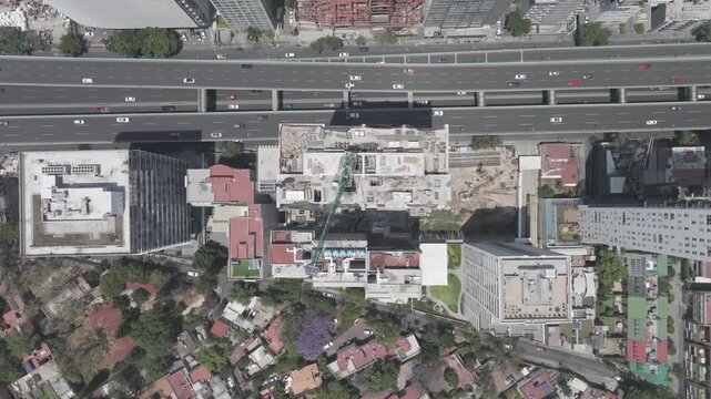 
Title: Aerial drone top down view of building under construction and Perif&eacute;rico highway traffic in M&eacute;xico City. Shot in D-Log M
