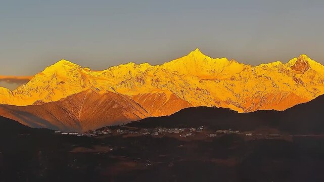 A dramatic close-up timelapse focusing on the intense golden sunlight hitting the snow-capped peak of Meili Mountain at dawn.