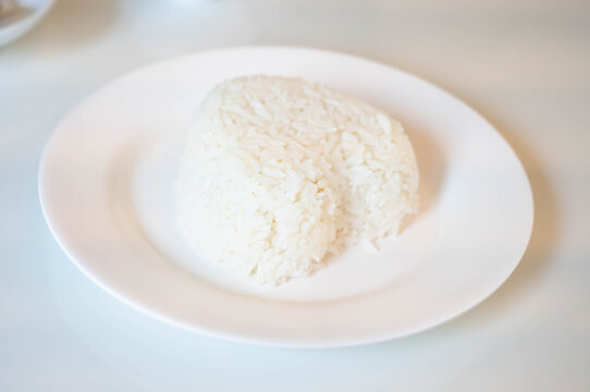 Steamed white rice served on a clean white plate, close up simple carbohydrate food, staple meal concept with soft texture, healthy energy source, minimal style food presentation for daily dining