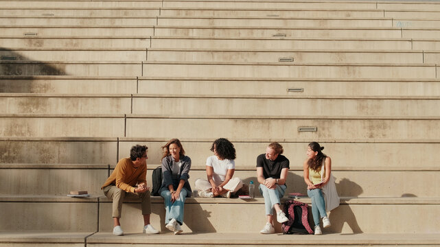 Friends Studying Together On Concrete Bleacher Steps