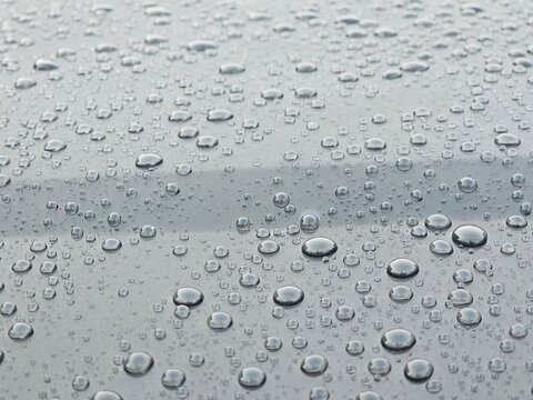 Clear raindrops and water droplets on grey metallic surface background