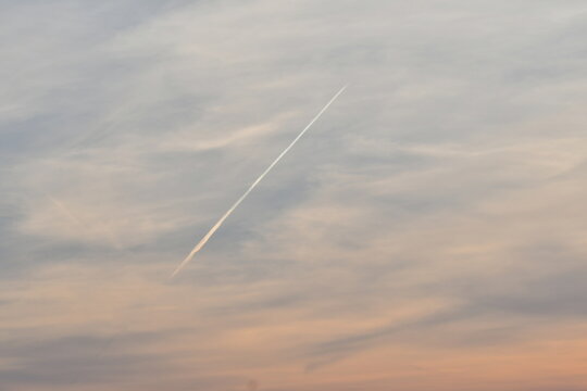 Contrail in Cloudy Sky
