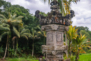 Obraz premium Ornate Balinese Stone Pillar in Lush Jungle
