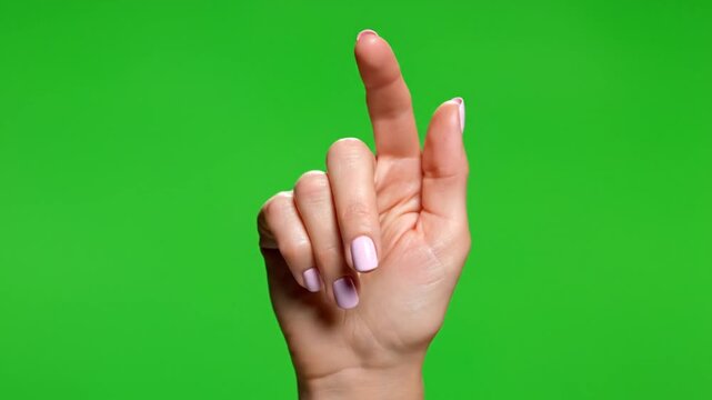 Female hand with index finger pointing up, ready to touch or select on a green screen background.
