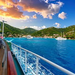Naklejka premium A scenic coastal view captured from a vessel, featuring a vibrant turquoise sea, lush green hills, and a picturesque town under a colorful sky