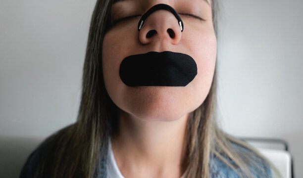Woman using nasal strip and mouth tape for better sleep and breathing - Biohacking and wellness concept - ugc content