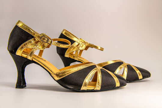Black and golden women's shoes for Latin dance and tango on the white background