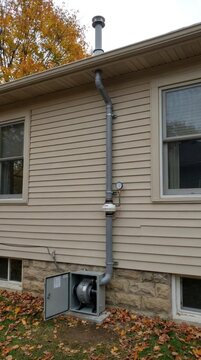 Radon mitigation system installed on house exterior