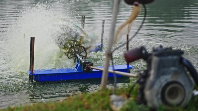 Diesel Engine with running paddle wheel aerator in aquaculture pond at bhimavaram, andhra pradesh, india. day time, stable shot, 4k.