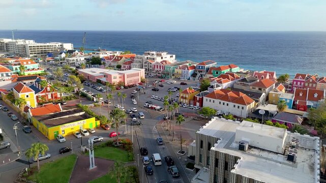 Drone view of Pietermaai waterfront at sunset with colorful heritage buildings and ocean beside the district.