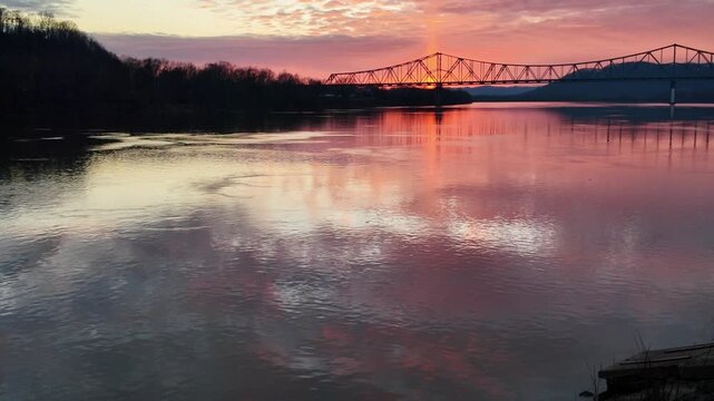Ohio River at Sunset in Portsmouth, Ohio at sunset with red and orange reflections coming off the waves