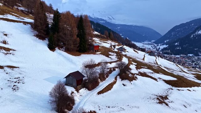 Aerial fly snowy ski slopes and winter resorts in Nauders Austria, alpine mountain landscape daylight