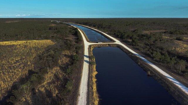 Drone reveal along a canal at the John C. and Mariana Jones Hungryland Wildlife Environmental Area that shows the vastness and diversity of the area including lakes, ponds, canals and prairies.