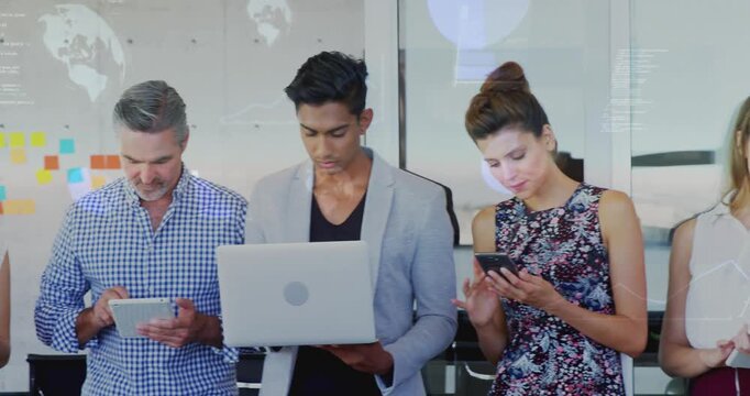 Revealing team with camera panning in office, in business attire and reviewing notes on devices