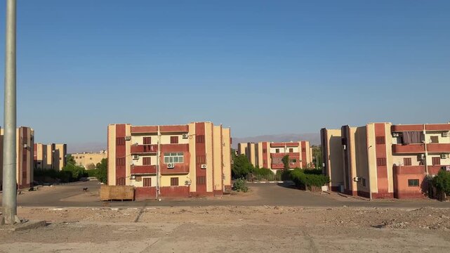 Public housing buildings in desert neighborhood of Nuweiba. View from moving car window
