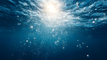 Fototapeta premium Abstract underwater background with blue water surface and many rising oxygen bubbles in bright sunlight.