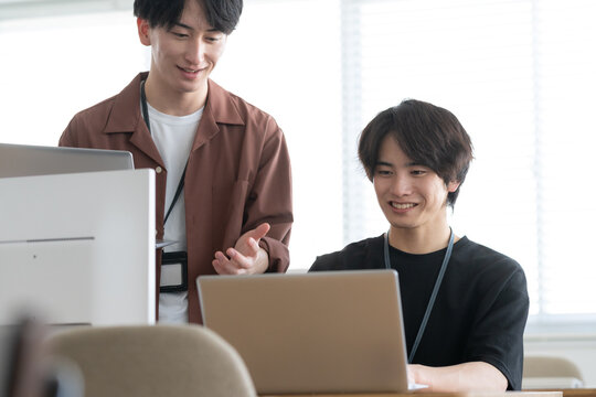 オフィスのパソコンで仕事をする若い男性エンジニア