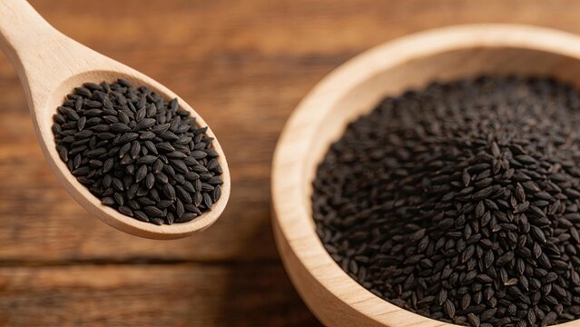 Black cumin seeds on wooden spoon and bowl healthy organic spice for cooking natural food ingredient closeup view on rustic table background