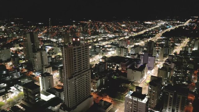 Nighttime drone footage of buildings in downtown Chapec&oacute;.