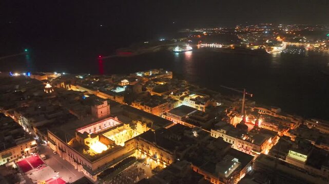 Malta, Valletta's illuminated harbor and cityscape sparkle under the night sky, showcasing vibrant nightlife.