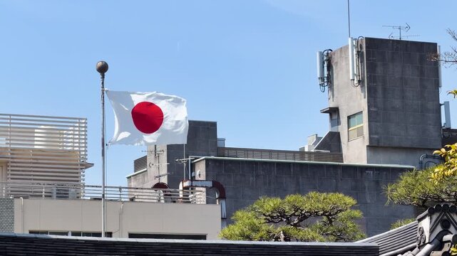Japanese Flag Hinomaru Waving on Rooftop in Kyoto Urban Setting