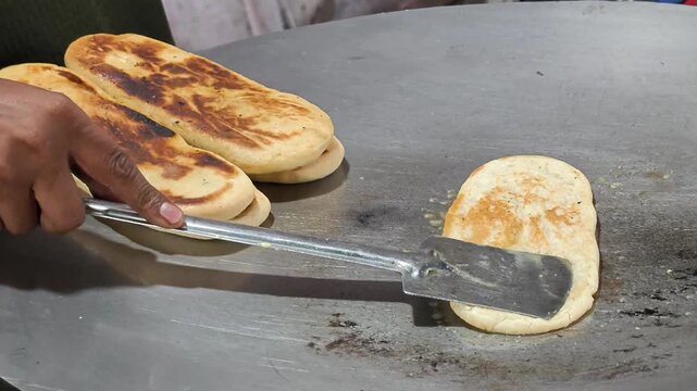 Close up of Kulcha being toasted with butter on a griddle