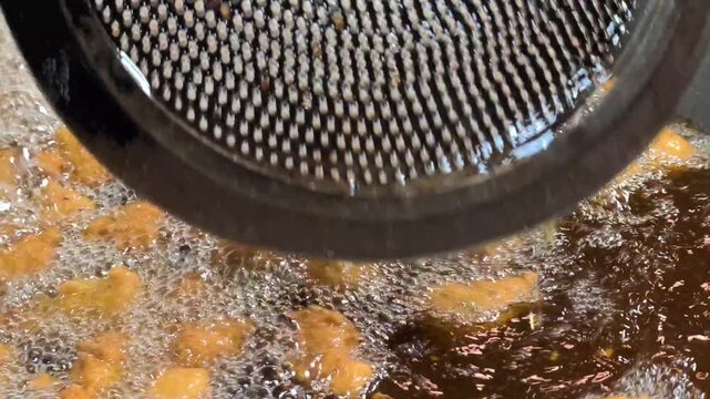 Close up of moong dal mangodi being deep fried in hot oil
