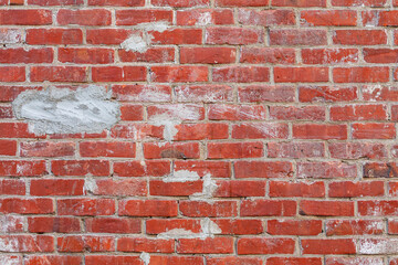 Fototapeta premium old red brick wall with grey cement patches texture background
